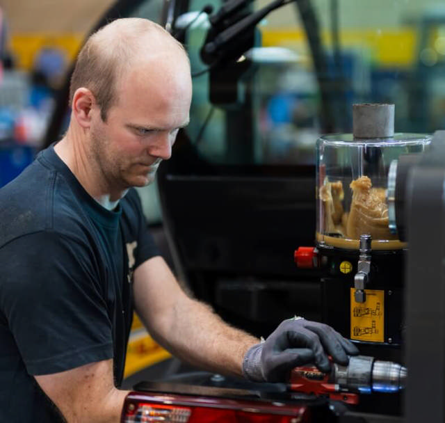 Montør installerer centralsmøring på maskine.