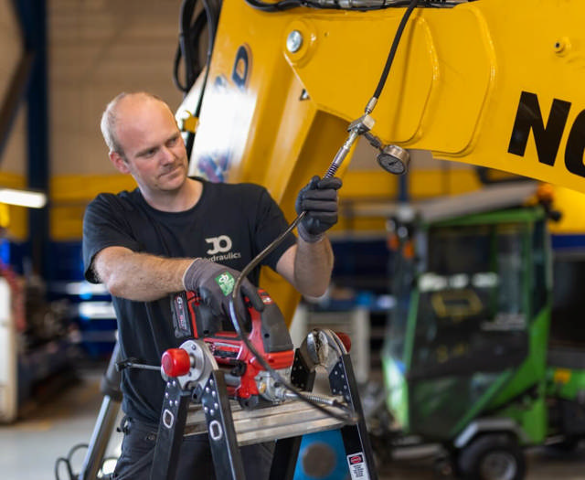 Centralsmøringsmontør afkorter og tilpasser slanger i forbindelse med montering af centralsmøringsanlæg